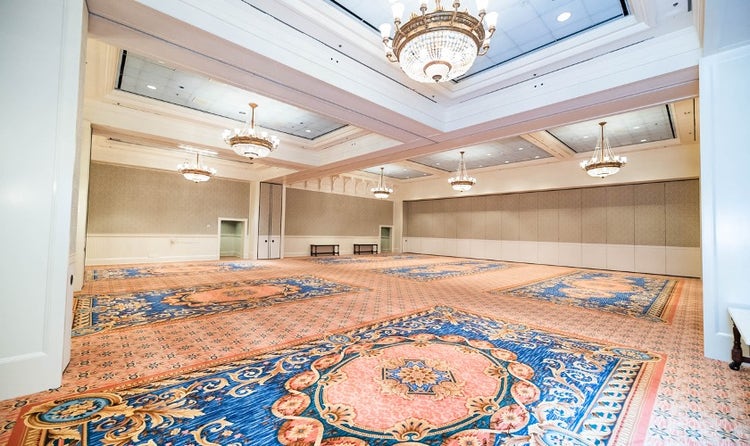 A spacious ballroom at Disney's BoardWalk Inn featuring high ceilings and chandeliers