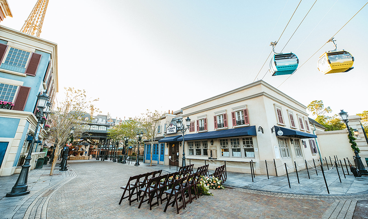 Two cars on the Disney Skyliner pass over the France Pavilion