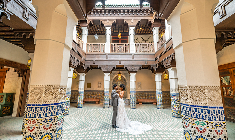 A bride and groom dancing together in a Moroccan themed indoor courtyard