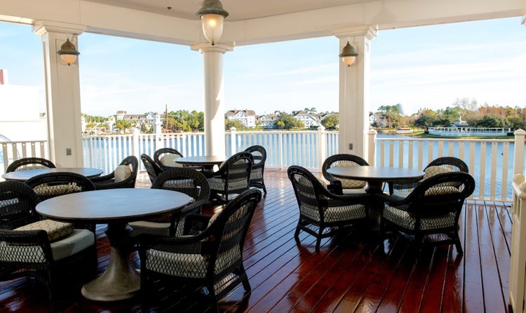 An outdoor seating area on a balcony overlooking Crescent Lake at Disney's BoardWalk