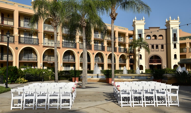 Two sections of chairs arranged in rows in a courtyard facing a large water fountain