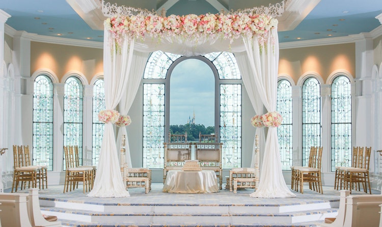 The interior of a wedding chapel with customized floral arrangements and a havan kund for an Indian wedding