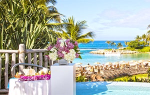Two pillars with bouquets of flowers overlooking a beach