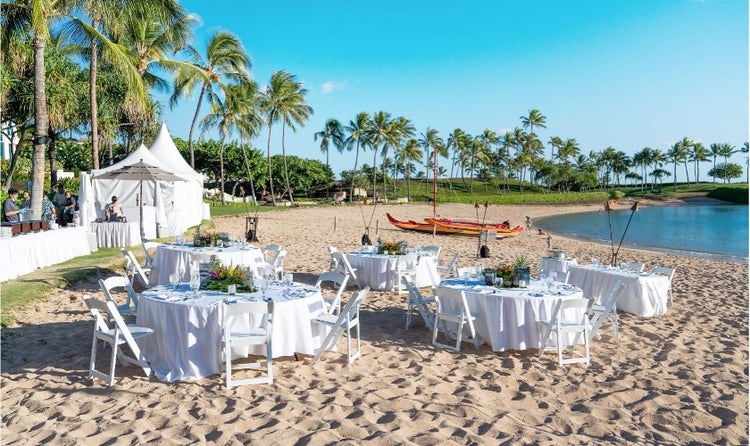 Chairs and tables set up along Aulani Beach in front of the ocean at Aulani, A Disney Resort and Spa