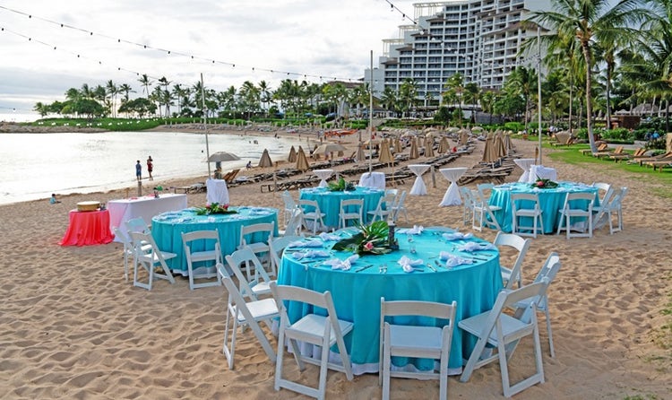 Chairs and tables set up along Aulani Beach in front of the sea