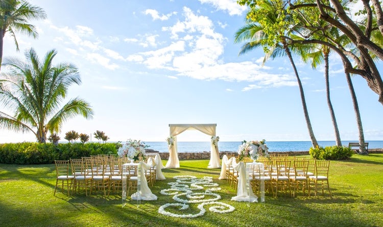 Chairs lined up in front of an arch overlooking the beach of Lanikuhonua