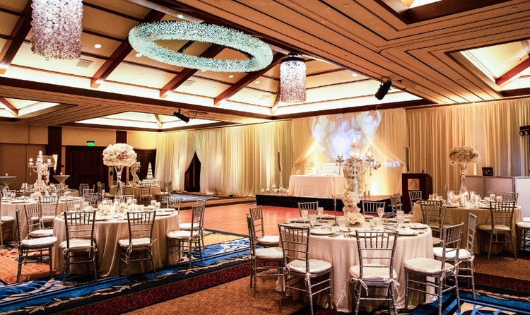 The spacious Kaiona Ballroom featuring tables and chairs around a dance floor