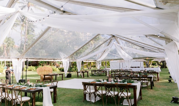 Tables and chairs beneath a large tent surrounding a dance floor