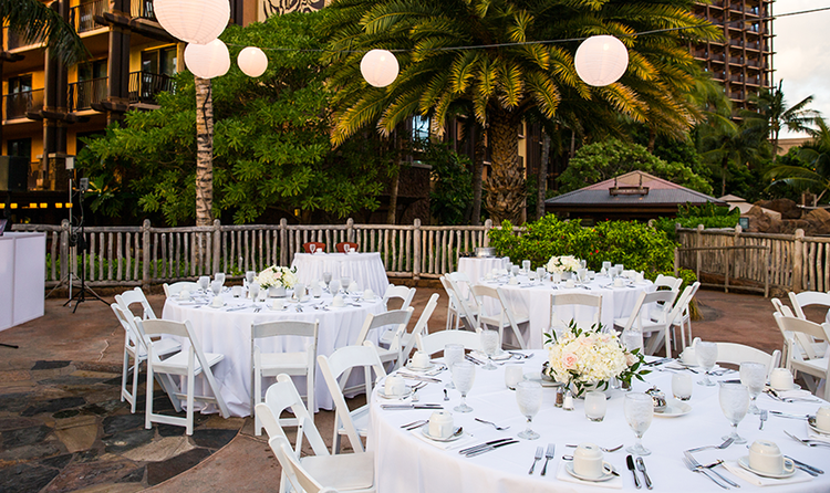 Three tables with place settings arranged under large lanterns