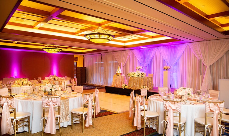 Several round tables, a small dance floor and a cake table