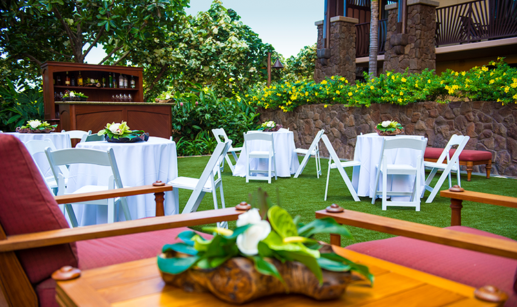 Wedding table settings with flower arrangements in a courtyard at Aulani, a Disney Resort and Spa