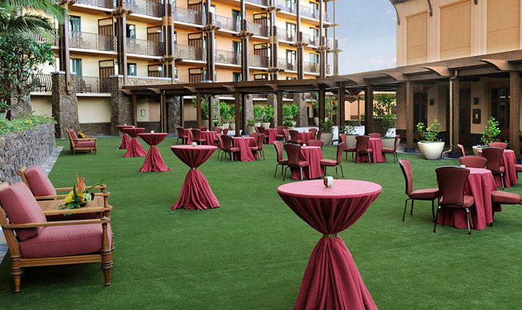 A fancy setting of dining and cocktail tables on the lawn of Aulani, a Disney Resort and Spa
