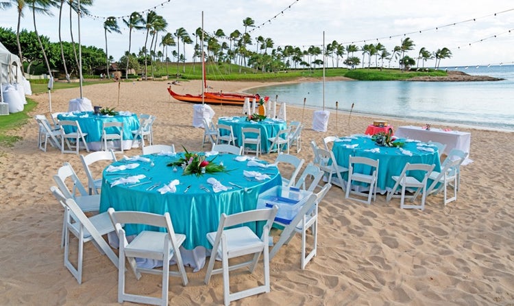 Chairs and tables set up along Aulani Beach in front of the ocean