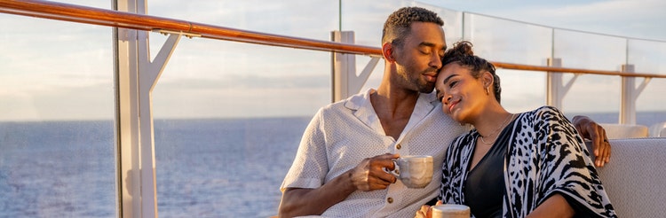 Newlyweds snuggling and enjoying hot beverages on a deck of a Disney Cruise Line ship