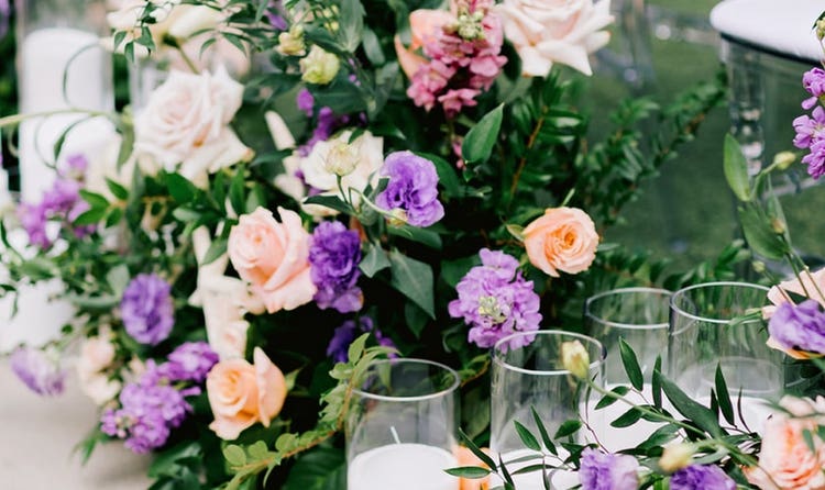 A lush garden style floral arrangement with candles and a starfish accent
