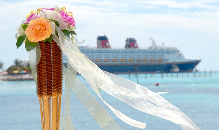 A bouquet of flowers on the top of a torch near a Disney Cruise Line ship