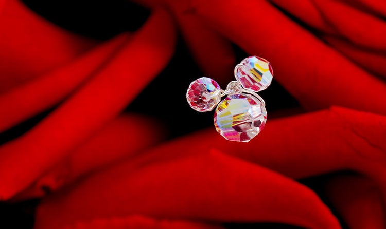 A Mickey Mouse shaped charm amid roses