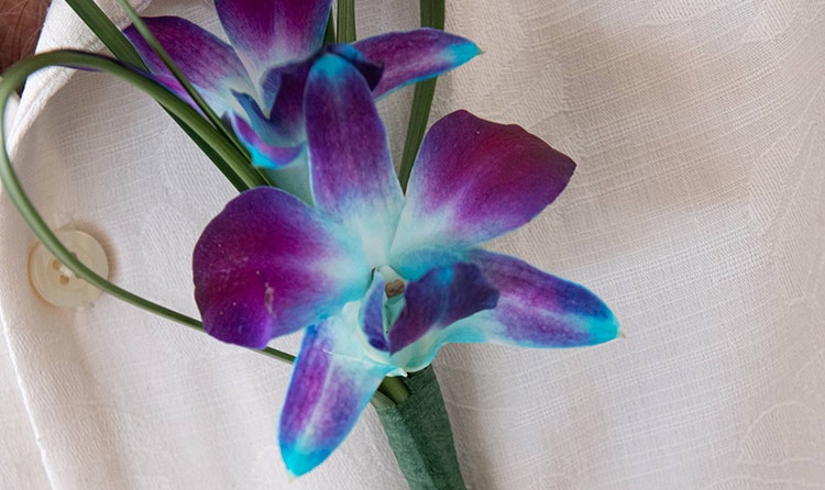 A groom wearing an orchid boutonniere