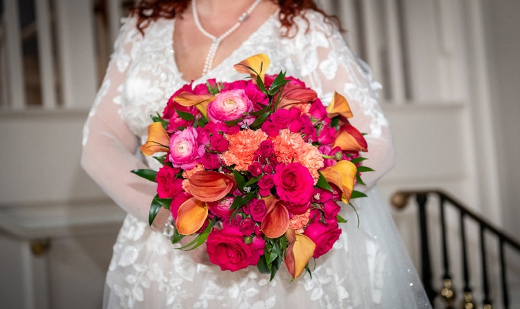 A bride holding a bouquet with roses, calla lilies and carnations