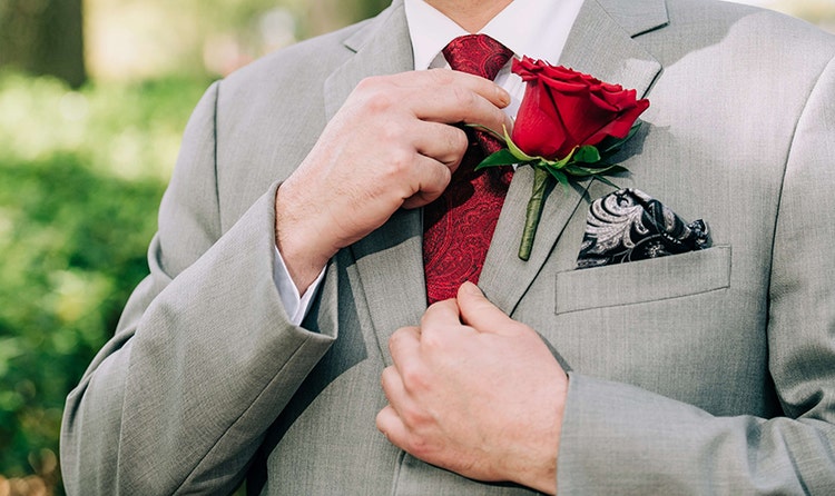 A groom wearing a rose boutonniere
