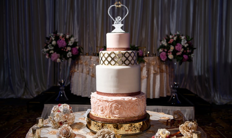 Wedding cake with crystal topping on table with flowers