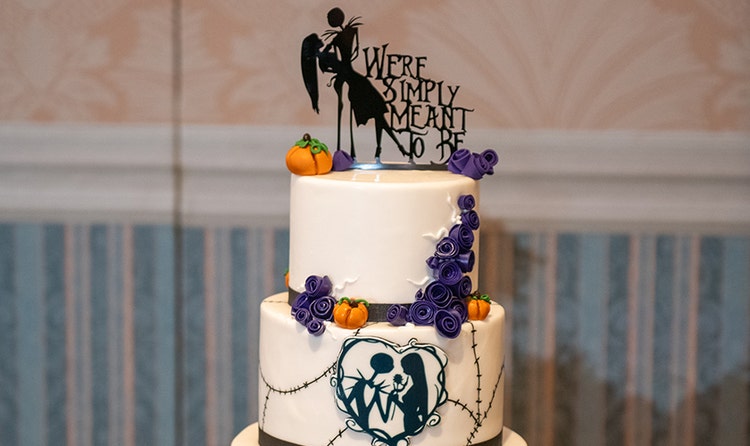 Wedding cake featuring a gothic gate design, a Jack and Sally silhouette, pumpkins and a Jake and Sally 'We're Simply Meant to Be' topper