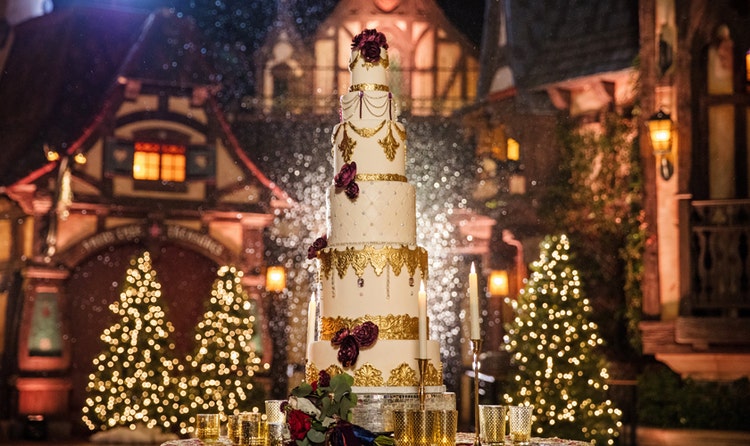 Wedding cake with gold decoration in front of Christmas trees